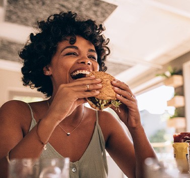Woman smiling while enjoying meal in restaurant