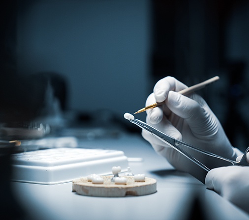 a technician crafting a dental crown in a laboratory