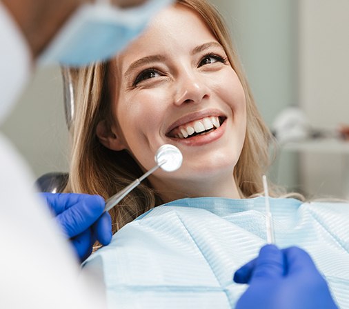 a patient having her teeth examined by a dentist